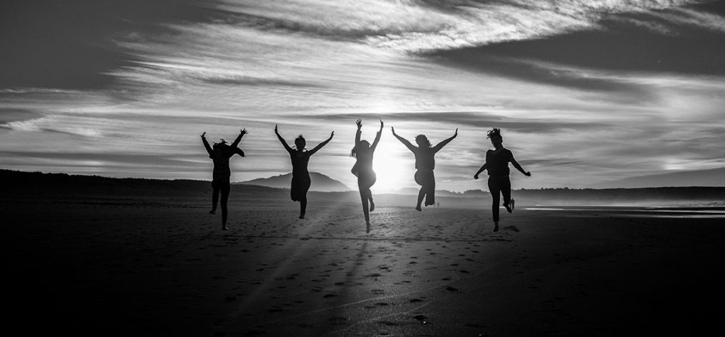 Metas a mediano plazo mujeres en la playa saltando